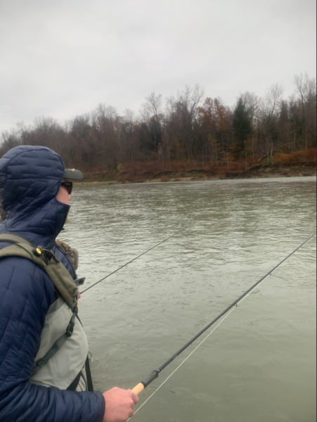 An angler fishes a large river for steelhead