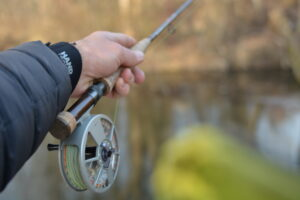 A fly rod in a hand while fly fishing in winter