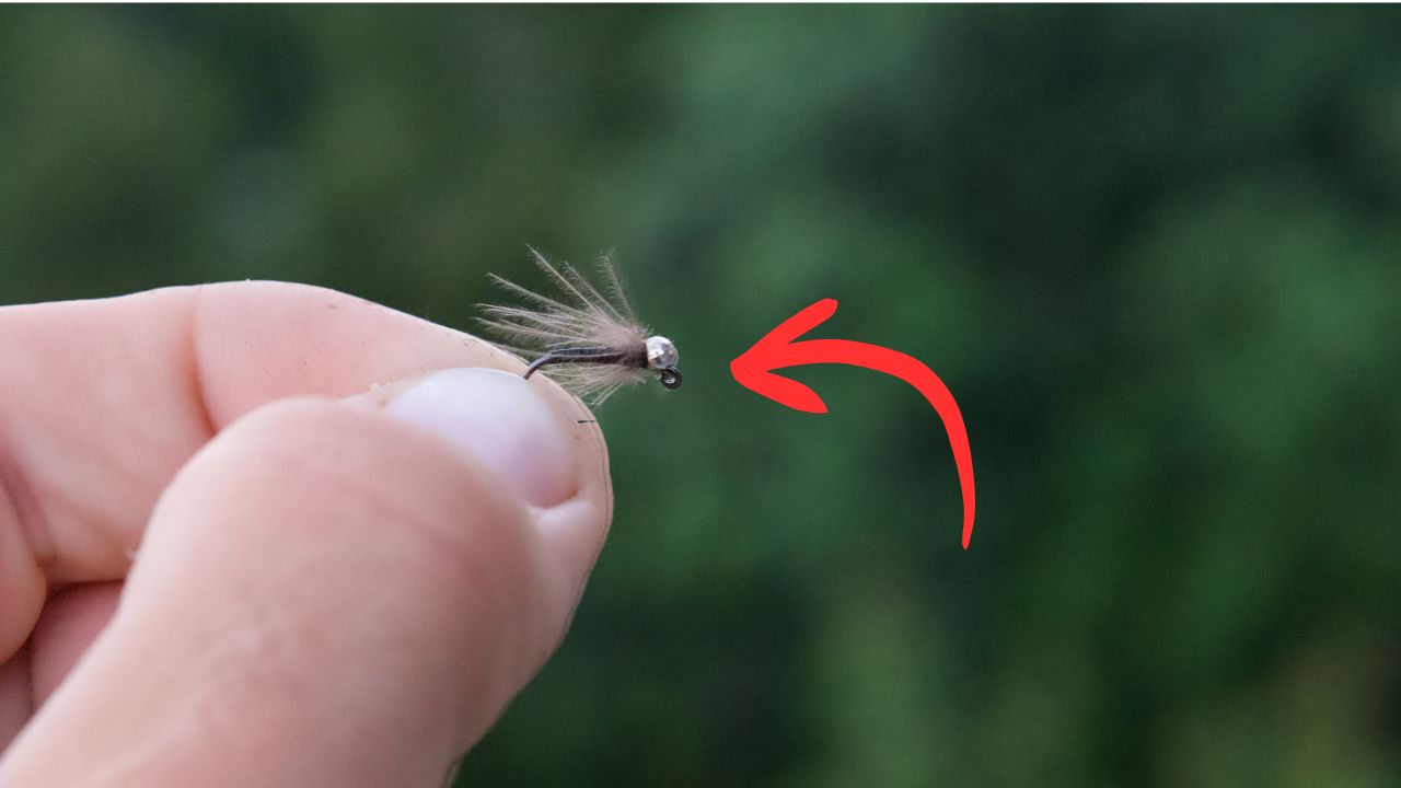 A CDC France Fly in an anglers hand