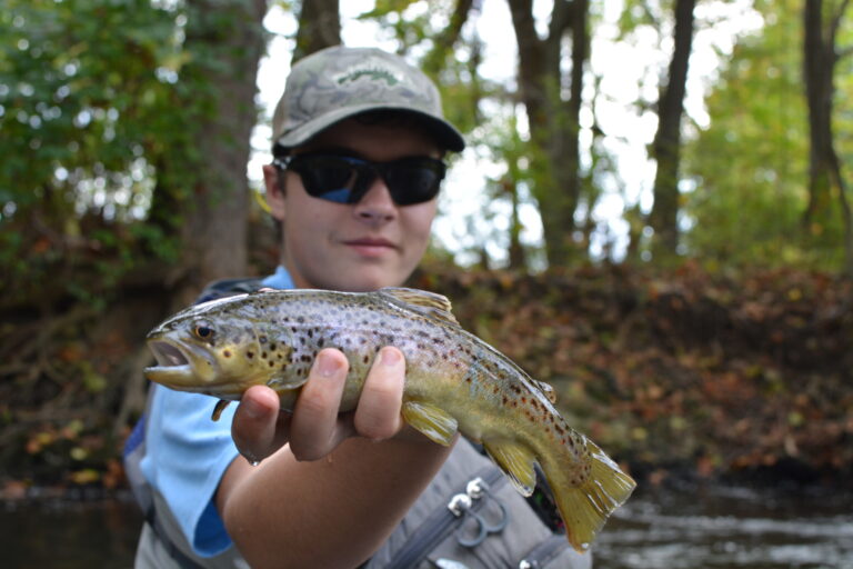 A young fly angler with a stocked brown trout