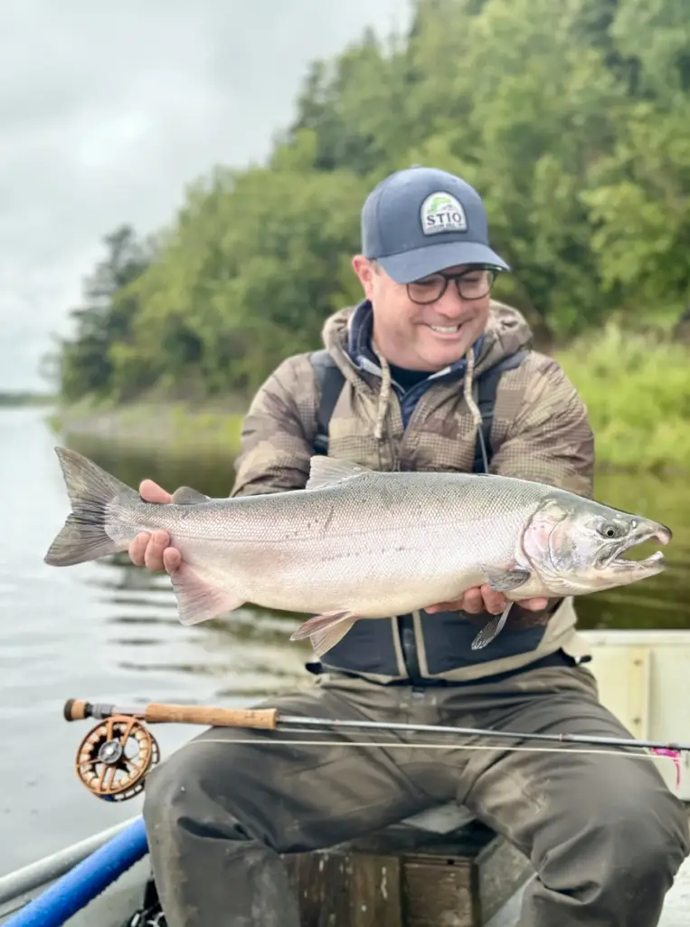 An angler with a silver salmon from Alaska